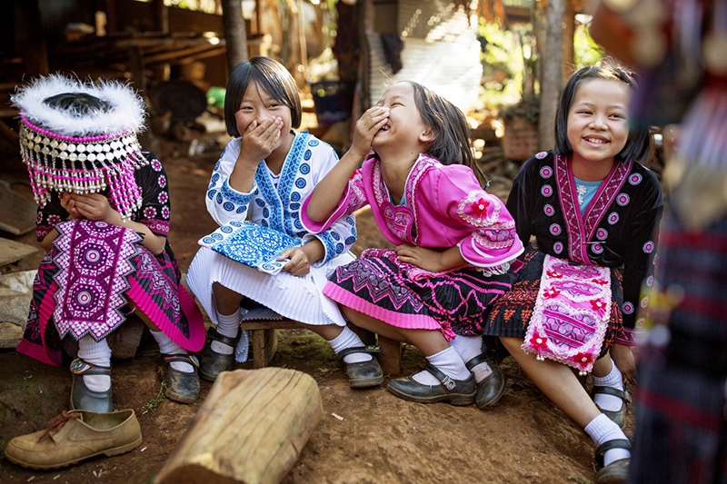 Young vilage girls laughing out loud when one of the ambassadors reading a book to them in Khun Yuam district, Mae Hong Son province, Thailand.