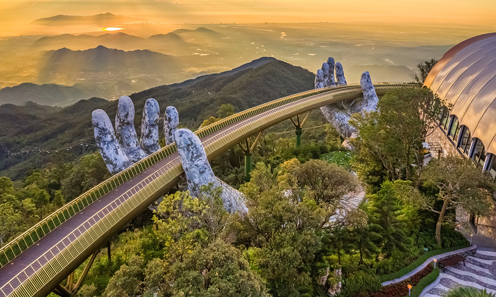 Aerial view of the Golden Bridge is lifted by two giant hands in the tourist resort on Ba Na Hill in Da Nang, Vietnam. Ba Na mountain resort is a favorite destination for tourists
