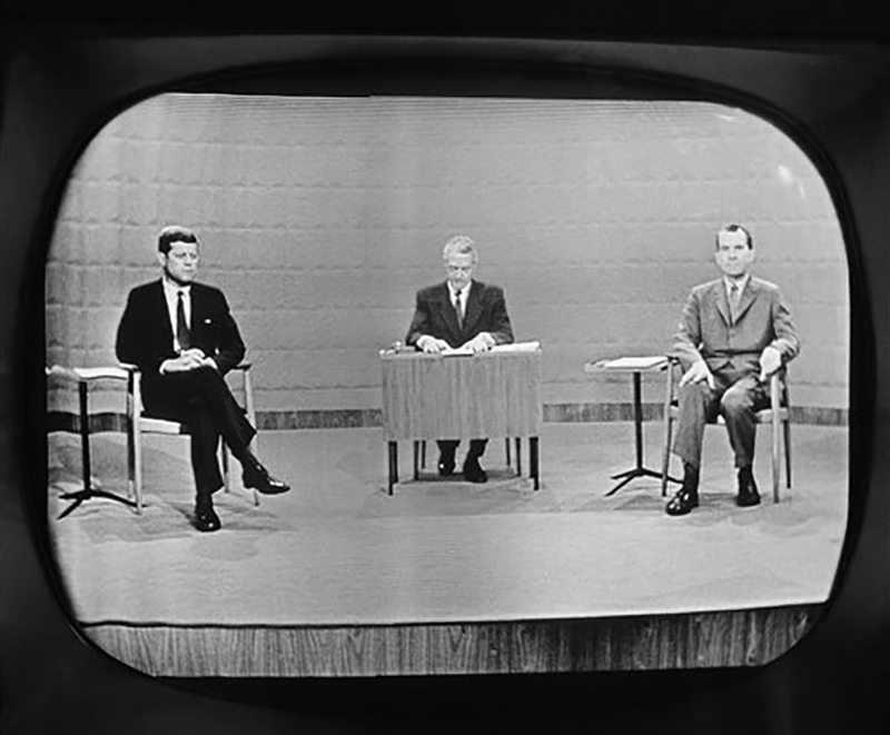 FILE - In this Sept. 26, 1960 file photo, moderator Howard K. Smith sits between, Sen. John Kennedy, left, and Vice President Richard Nixon as they appear on television studio monitor set during their debate in Chicago. The Kennedy image, the "mystique" that attracts tourists and historians alike, did not begin with his presidency and is in no danger of ending 50 years after his death. The multimedia story began in childhood with newsreels and newspaper coverage of the smiling Kennedy brood, and it continued with books, photographs, movies and finally television, notably the telegenic JFK’s presidential debates with Nixon. (AP Photo)